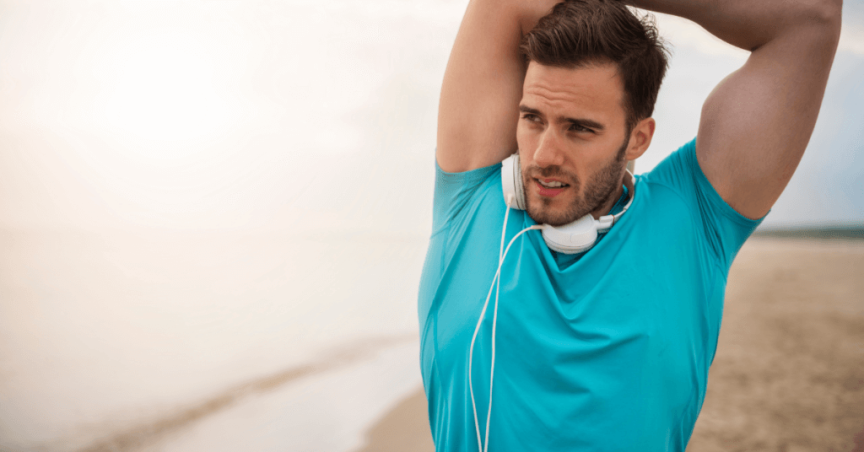 man stretching on beach