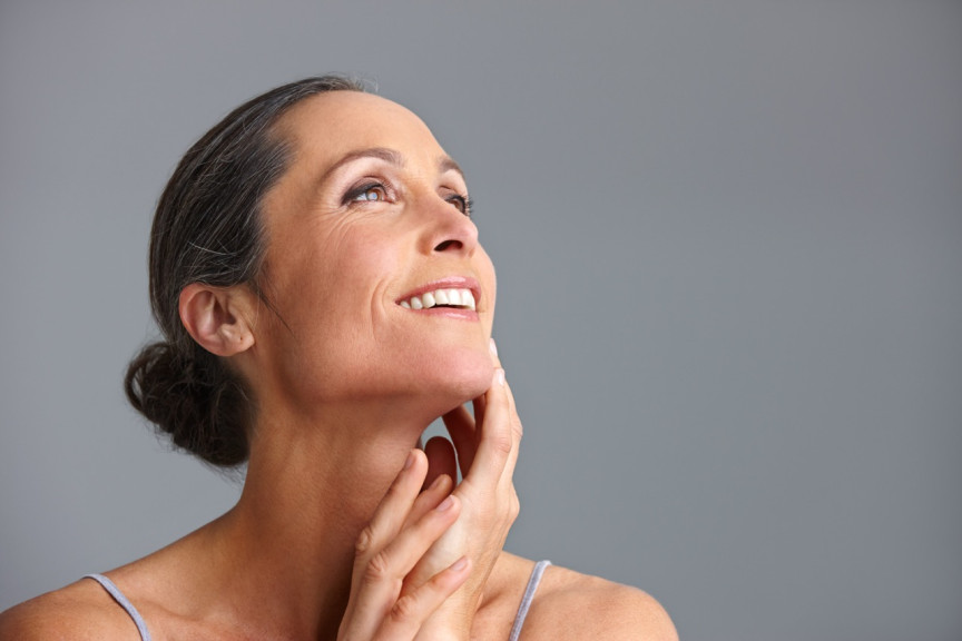 smiling mature woman with salt and pepper hair pulled back in a bun