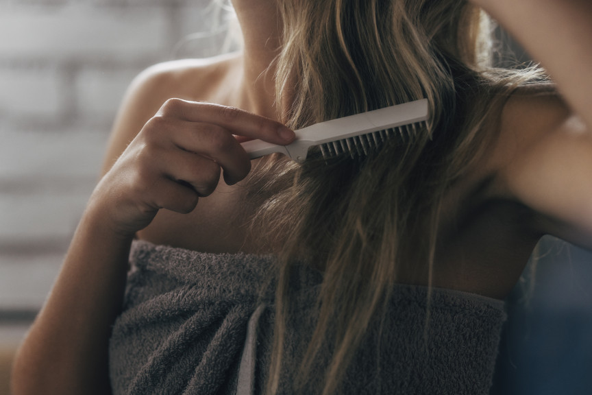 Woman brushing her hair after shower