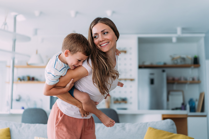 woman giving small boy a piggyback ride